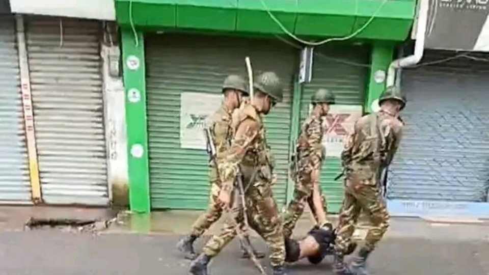 গোপালগঞ্জে আহত এক যুবককে টেনেহেঁচড়ে নিয়ে যাচ্ছেন বাংলাদেশের সেনা সদস্যরা।