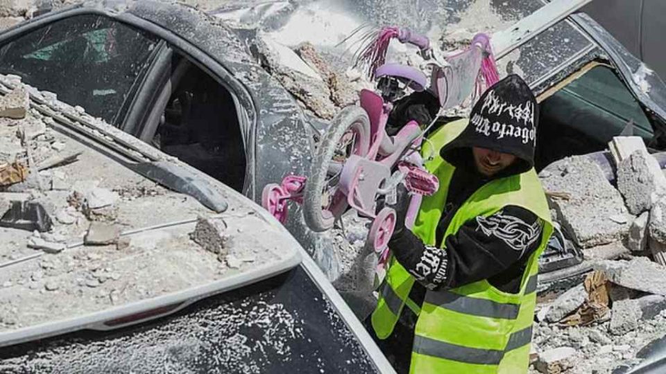 ইসরায়েলের মধ্যাঞ্চলের একটি ক্ষতিগ্রস্ত ভবন থেকে শিশুদের একটি সাইকেল উদ্ধার করে নিয়ে যাচ্ছে এক ব্যক্তি। ছবি: রয়টার্স