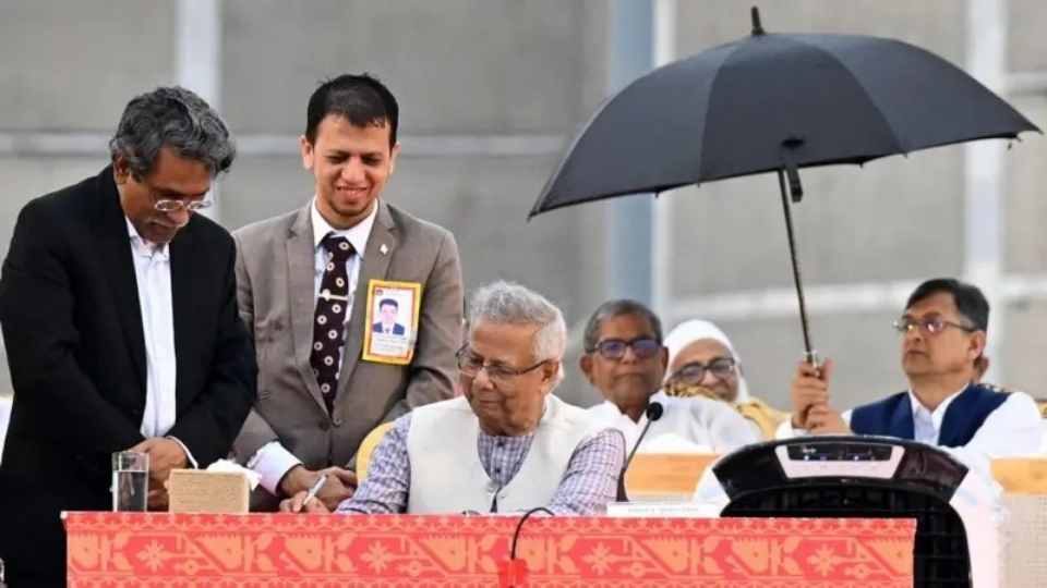 জুলাই সনদে সই করার দিনে প্রধান উপদেষ্টা মুহাম্মদ ইউনূসের পাশে ছাতা হাতে বিএনপির নেতারা। ফাইল ছবি